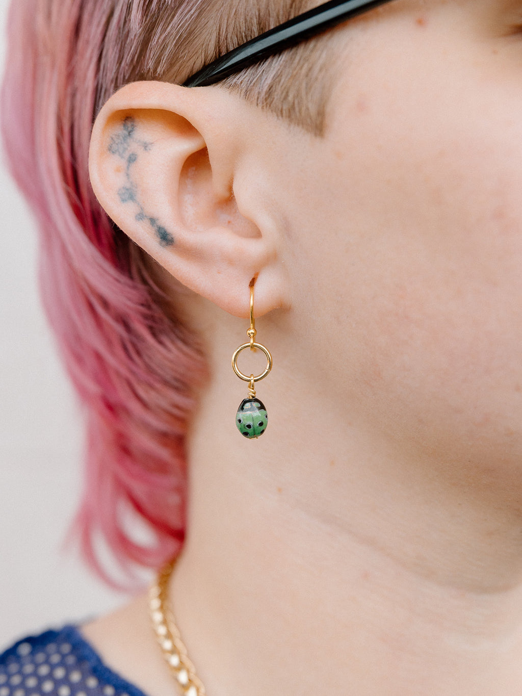Model Wearing Green “Lucky” Lady Bug Earrings With Gold Ring and Hook