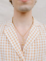 Closer Up Image of Model Wearing Golden Rose Necklace With Gold Ring and Chain