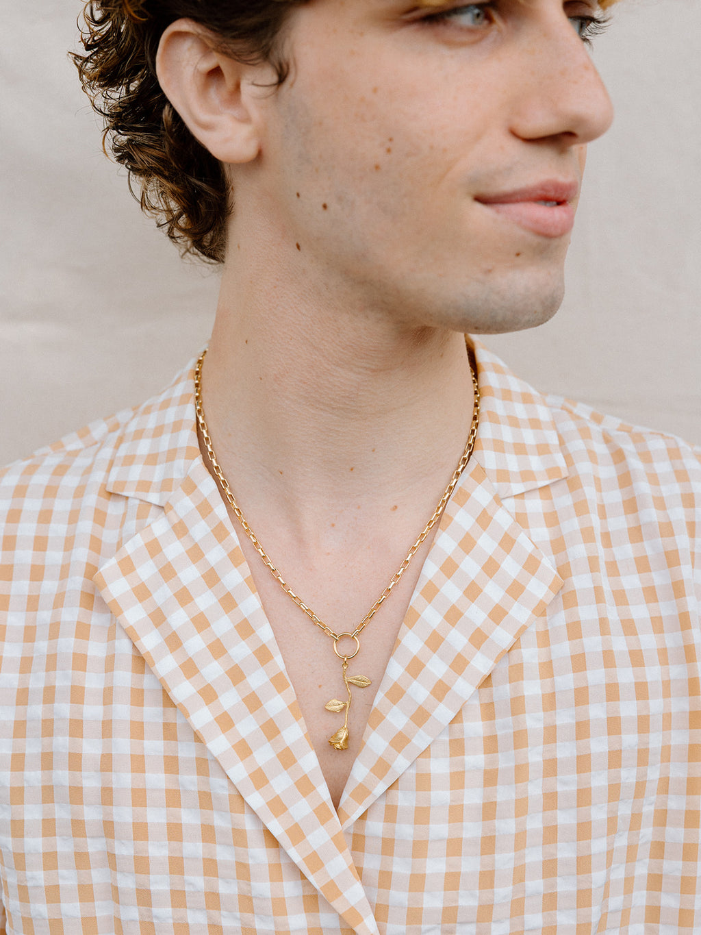 Model Wearing Golden Rose Necklace With Gold Ring and Chain