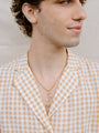 Model Wearing Golden Rose Necklace With Gold Ring and Chain
