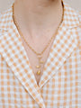 Closer Up Image of Model Wearing Golden Rose Necklace With Gold Ring and Chain