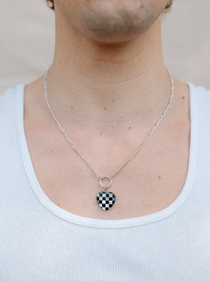 Closer Up Image of Model Wearing Checker Board Heart Necklace With Silver Ring and Figaro Chain