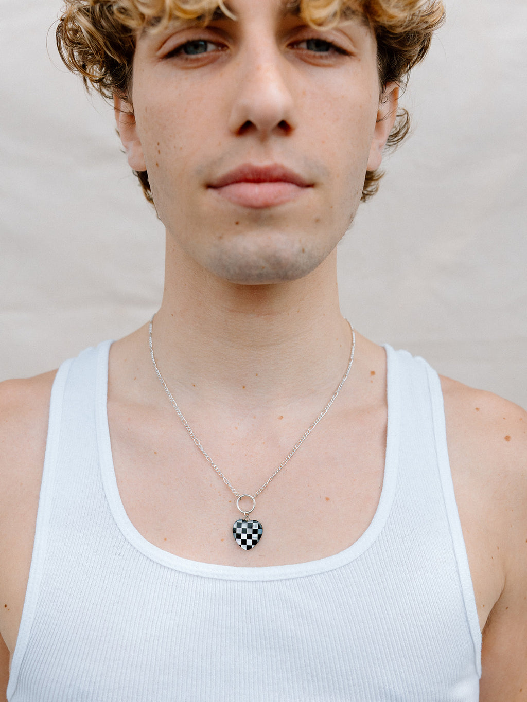 Model Wearing Checker Board Heart Necklace With Silver Ring and Figaro Chain