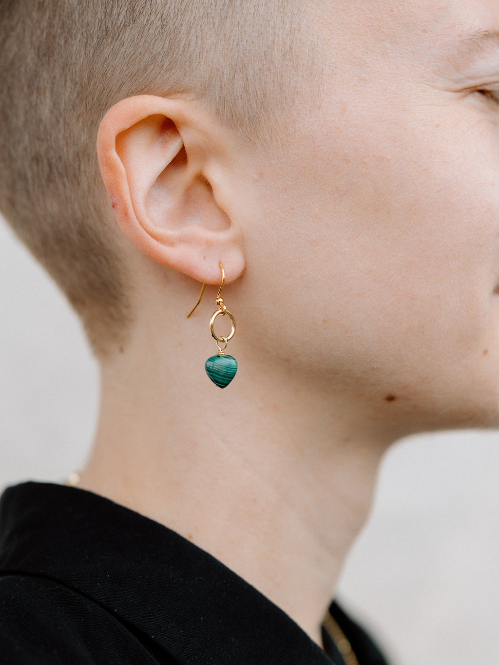 Model Wearing Small Malachite Heart Earrings With Gold Ring and Hook