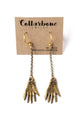 Brass Hand Charm Earrings on Brass Chains on a Brown Card